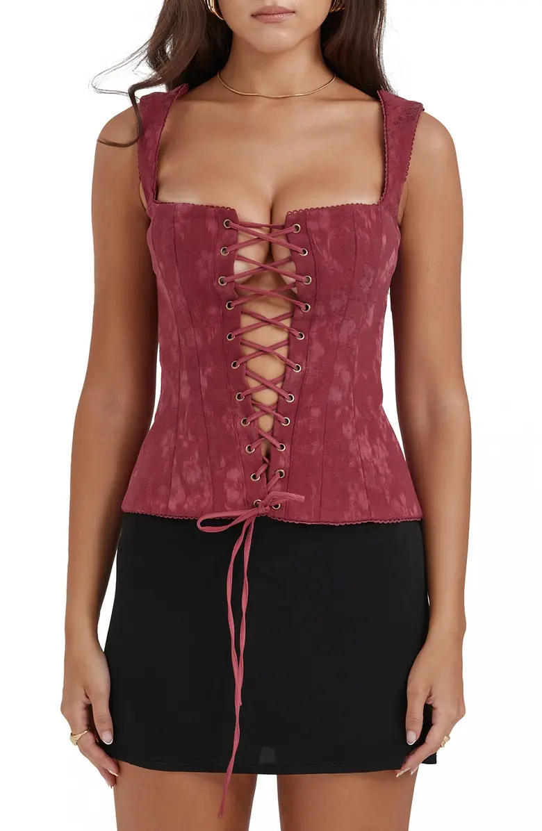 Model wearing a burgundy Parisa Lace-Up Corset Top with Front lace-up closure and a square neck by House of CB with a black skirt.